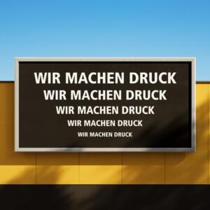 Ein schwarzes Schild, darauf in weißen Versalien WIR MACHEN DRUCK in fünf Schriftgrößen