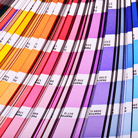 Ausgebreiteter Farbfächer mit Gelb- bis Blaunuancen des Farbsystems Pantone