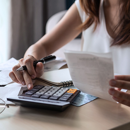 Eine Kalkulation am Taschenrechner symbolisiert das Budget, um den Messeauftritt zu planen.