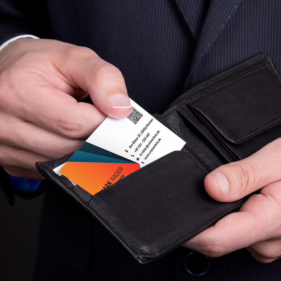 Mann hält Business Card in der standardisierten Visitenkartengröße in die Kamera.