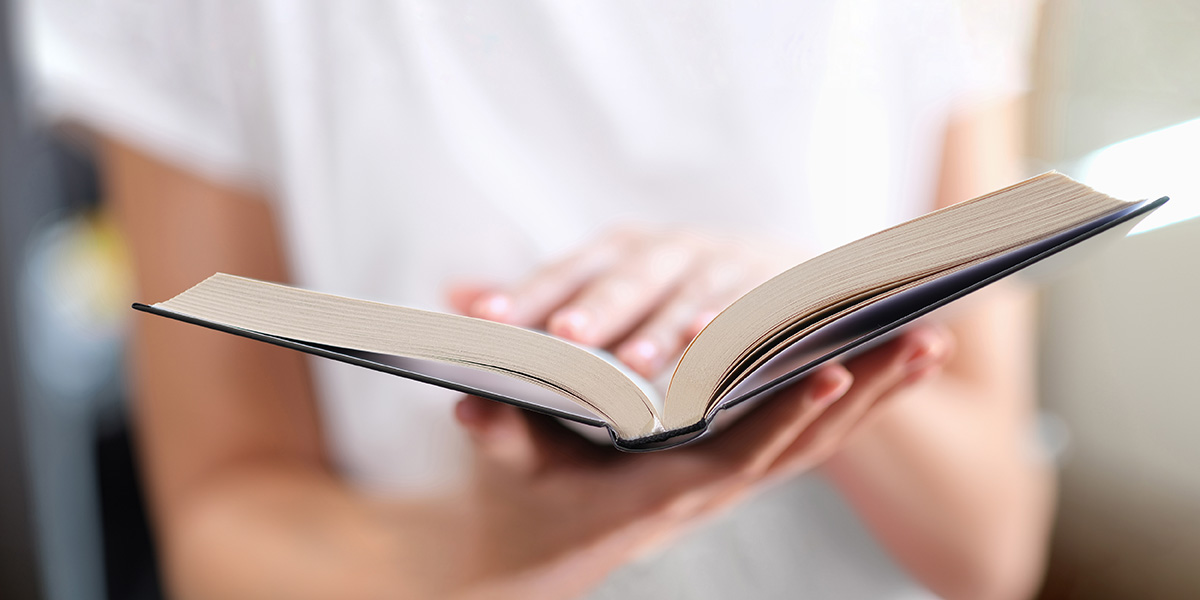 Erfolgreiches Selfpublishing: aufgeschlagenes Buch in den Händen einer Person