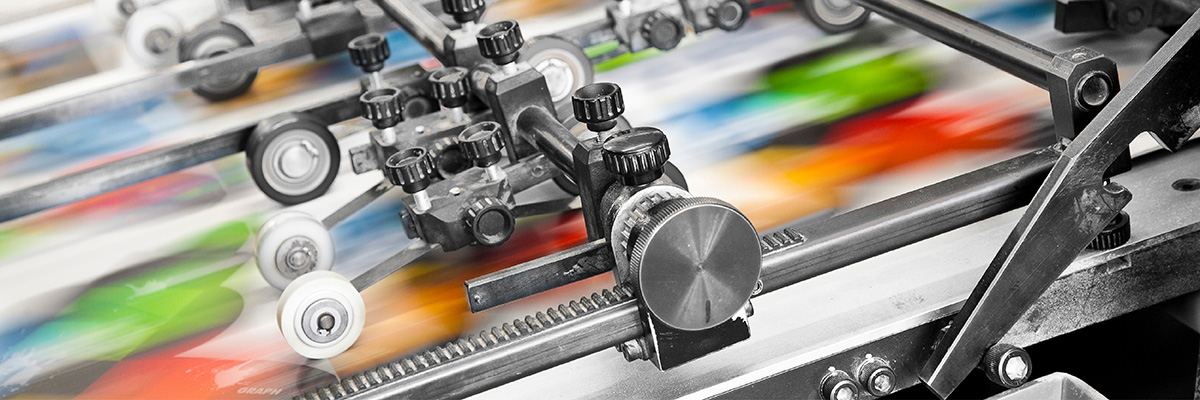 Druckproduktion 2026: eine Nahaufnahme einer Siebdruckmaschine beim Drucken eines bunten Druckmotivs