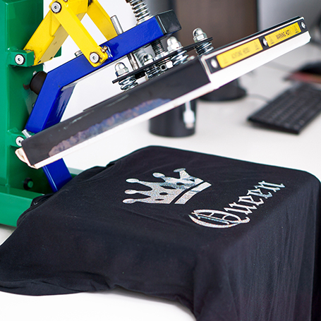 T-Shirt wird mittels Druckmaschine mit Kronen-Motiv und "Queen" bedruckt