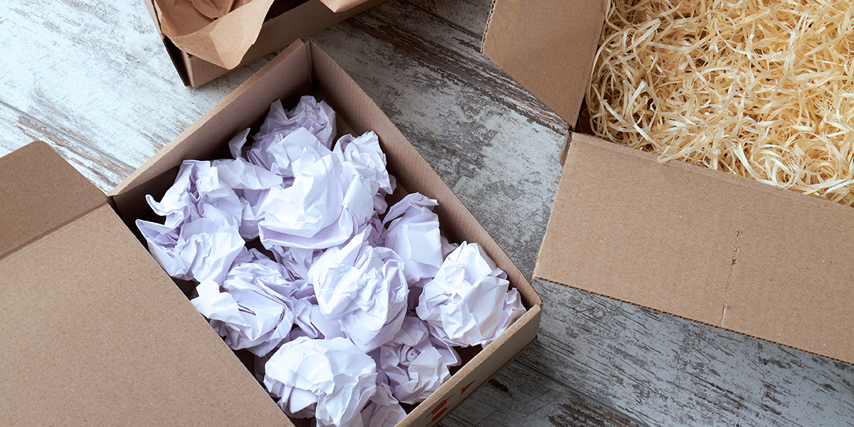 Verpackungsarten: offene braune Kartons mit Füllmaterial: geknülltes Papier und Holzwolle