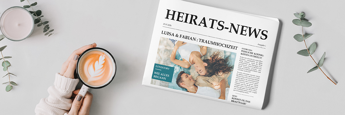 Hochzeitszeitung mit Paar-Foto auf weißem Tisch, daneben Hände mit Cappuccino-Tasse, Kerze & Zweigen