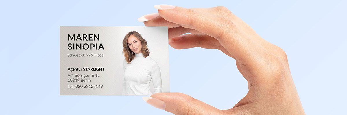 Visitenkartenidee: Hand hält Visitenkarte von Schauspielerin mit Gesicht und Kontaktdaten