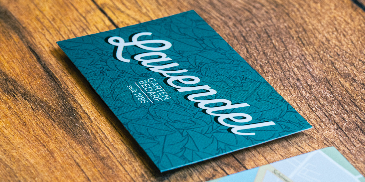 Visitenkartenidee mit typografischen Elementen: mit geschwungener Schrift und Blättermuster