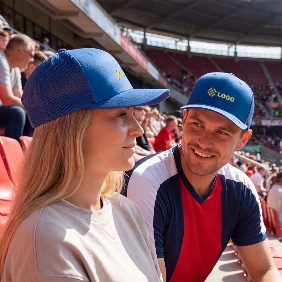 Eine Frau und ein Mann mit personalisierten FLEXFIT-Caps im Stadion