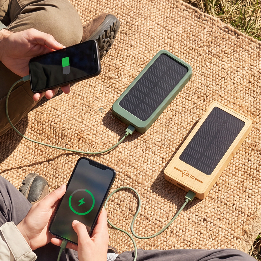 Zwei Solar-Powerbanks in der Sonne liegend, die jeweils ein Handy per Kabel aufladen