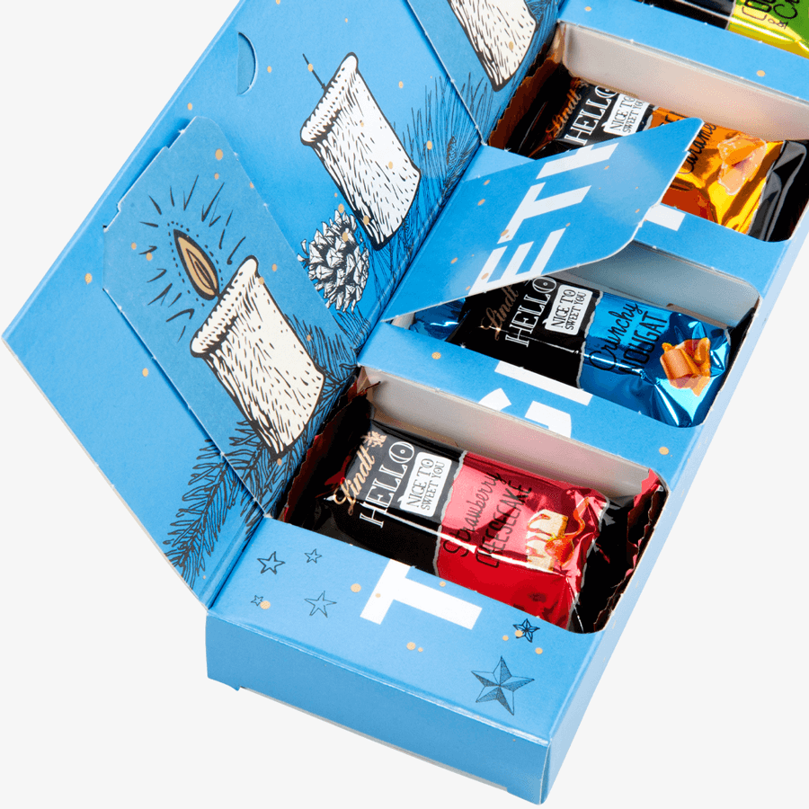 Nahaufnahme: bedruckter Lindt-Adventskalender als Adventsbox geöffnet: darin vier HELLO-Mini-Sticks