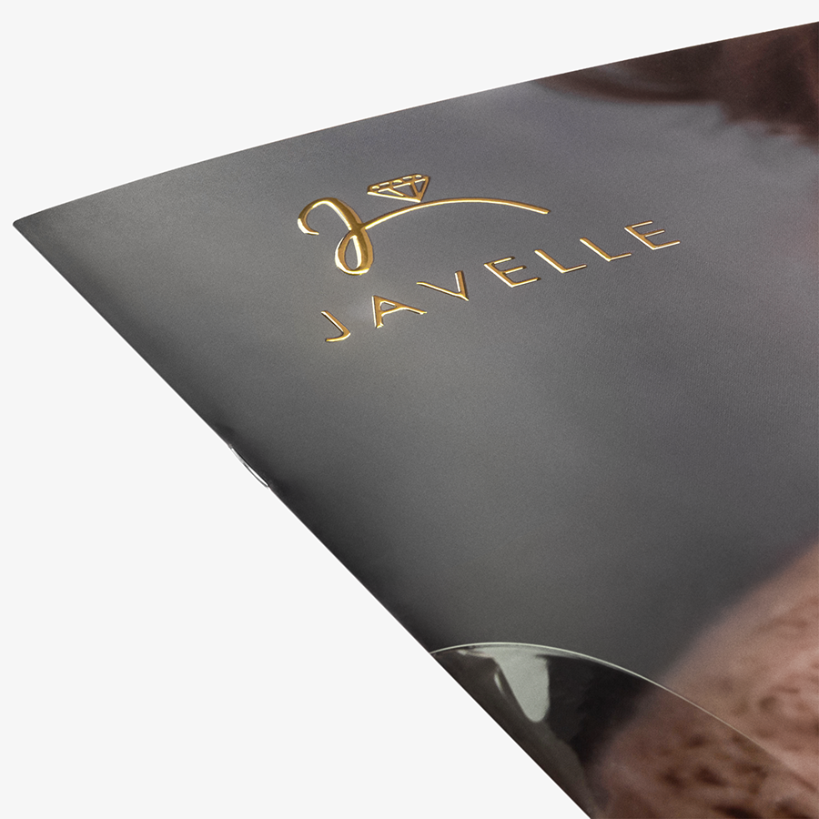 Detailansicht einer Broschüre mit Drahtheftung, veredelt mit goldenem Relieflack