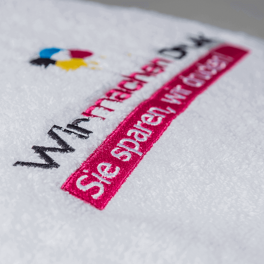 Detailansicht von weißem Handtuch mit individueller, mehrfarbiger Stickerei
