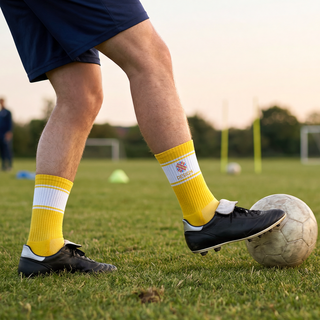 Fußballspielende Person trägt gelbe, individuell bedruckte Gripsocken mit weißen Streifen am Bein