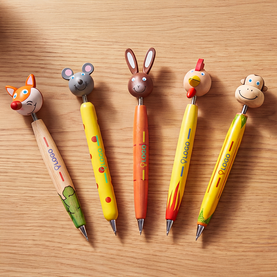 Fünf verschiedene Holz-Kugelschreiber mit Tierkopf und individuellem Druck liegen nebeneinander auf einem Holztisch