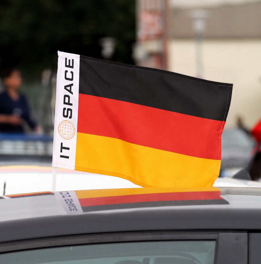 Mit Logo „IT SPACE“ individuell bedruckte Deutschland-Fahne, gesteckt auf Bande im Fußballstadion