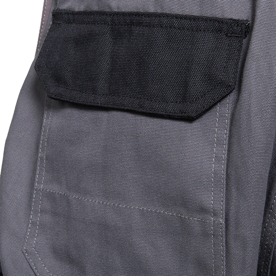 Detail-Ansicht einer schwarz-grauen Basic-Latzhose, individuell bestickte Arbeitskleidung