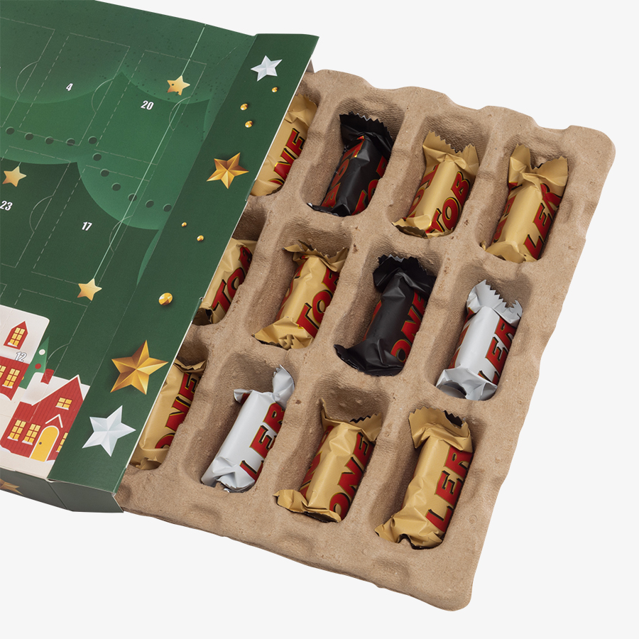 Seitlich geöffneter Wand-Adventskalender mit vollfarbigem Druck und Toblerone-Schokolade in drei Sorten als Füllung, Detailansicht des gefüllten Inlays, 