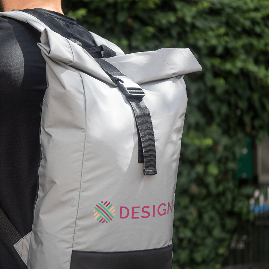 Person trägt individuell bedruckten, grauen Rolltop-Rucksack aus reflektierendem RPET-Material