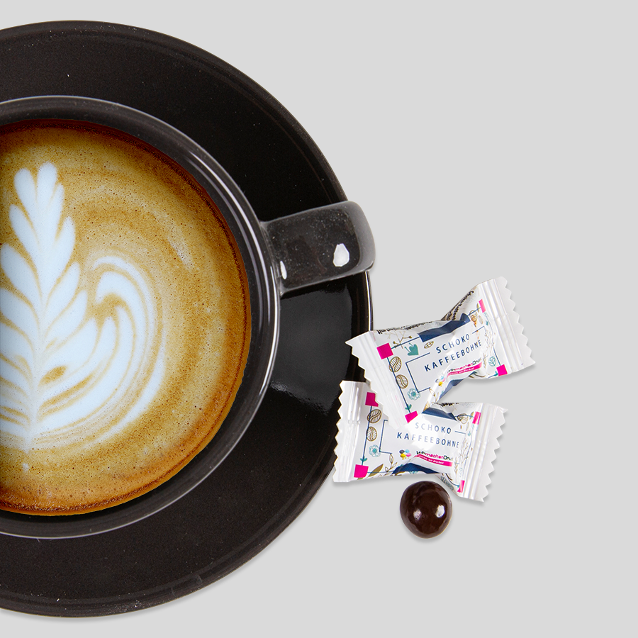 Schoko-Kaffeebohnen mit Zartbitter-Schokolade in individuell bedruckten Tütchen, Servierbeispiel mit Kaffee