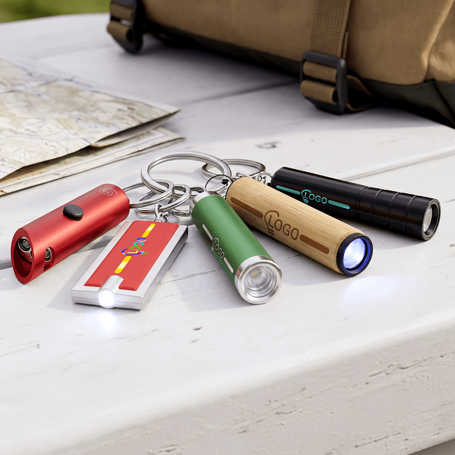 Unterschiedliche Taschenlampen-Schlüsselanhänger mit Personalisierung auf einem Tisch
