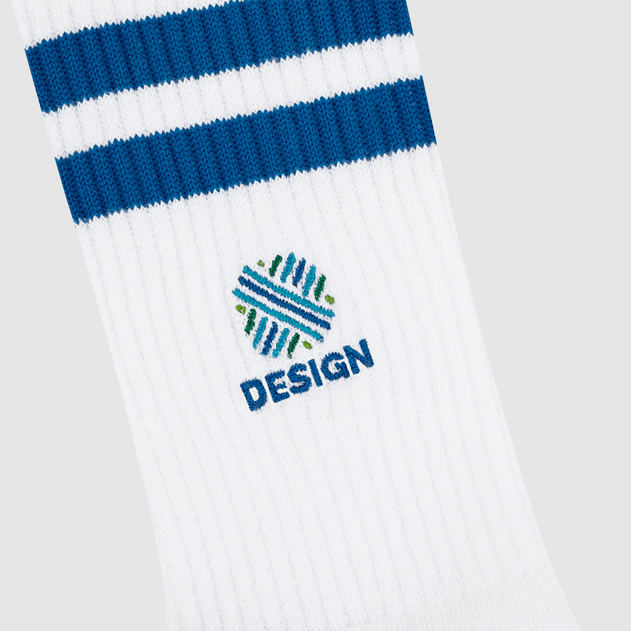Nahaufnahme einer weißen personalisierten Tennissocke mit blauen Ringeln und bunt aufgesticktem Logo