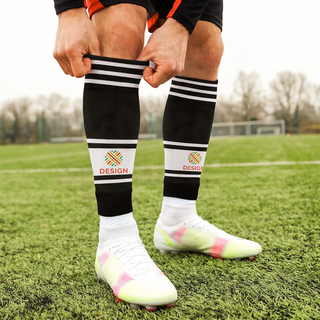 Person auf dem Fußballplatz trägt schwarze Stutzen mit individuellem Druck und weißen Streifen