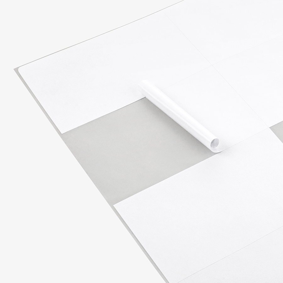 DINA-A4-Bogen mit selbst bedruckbaren, weißen Etiketten, ein Etikett abgerollt